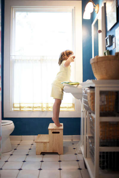 Side profile of a girl brushing her teeth in the bathroom